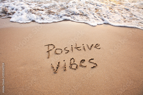 positive vibes, text on sand, optimism concept