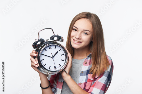 Portrait of smiling teen girl holding big clock