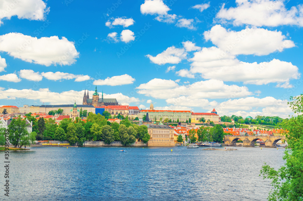 View of Prague old town, historical center with Prague Castle, St. Vitus Cathedral in Hradcany district, Charles Bridge Karluv Most, Vltava river, blue sky white clouds, Bohemia, Czech Republic