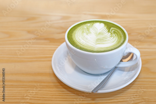 Matcha Japanese Green tea with cream milk form art on wood table.