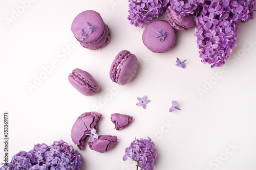 Branches of lilac and lilac macaron on a white background. Flat Lay Style