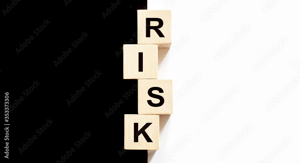 Business concept text on wood block Risk on the black and white background Business concept text on wood block Risk on the black and white background
