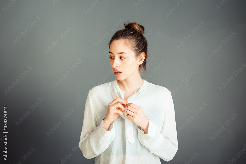 Serious girl with blindfolded hair on her head. Portrait. On a gray background. Without makeup, without retouching. Serious girl with blindfolded hair on her head. Portrait. On a gray background. Without makeup, without retouching.