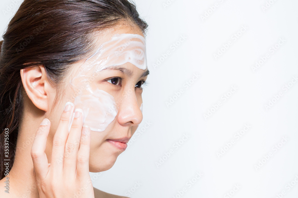 Young beautiful woman applying yogurt facial mask Skin care, beauty treatments on white background Young beautiful woman applying yogurt facial mask Skin care, beauty treatments on white background