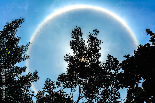 Sun with circular rainbow   Blue sky and corona natural white clouds