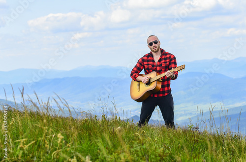 Hiker enjoy nature. Acoustic music. Musician hiker find inspiration in mountains. Keep calm and play guitar. Man hiker with guitar on top of mountain. Music for soul. Playing music. Sound of freedom