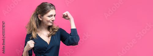 Happy young caucasian femalein lifts a clenched fist up for joy. Success and happiness of the work. Successful person, victory!