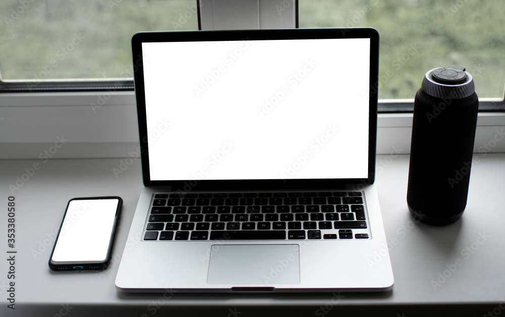 Fototapeta premium laptop with white screen for text on the window with phone and books
