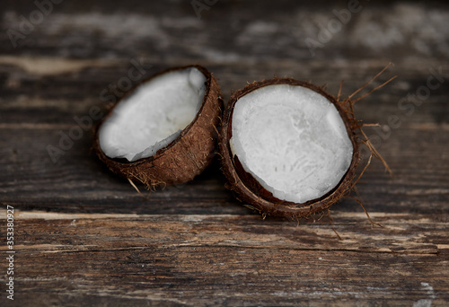 Ripe half cut coconut on a wooden background. Ripe half cut coconut on a wooden background. Coconut cream and oil.