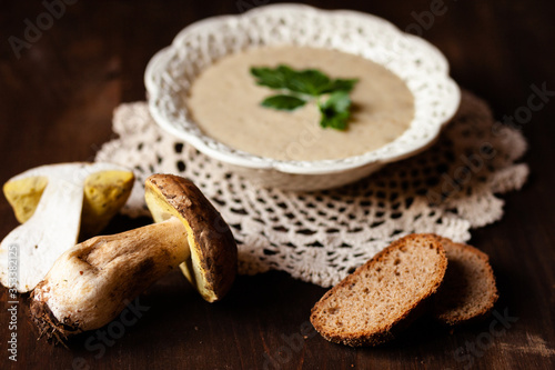 Delicious hot porcini puree soup  parsley. Tasty russian seasonal meal  perfect lunch. Fresh mashrooms as ingredients. Concept of homemade food. Closeup  dark wooden background