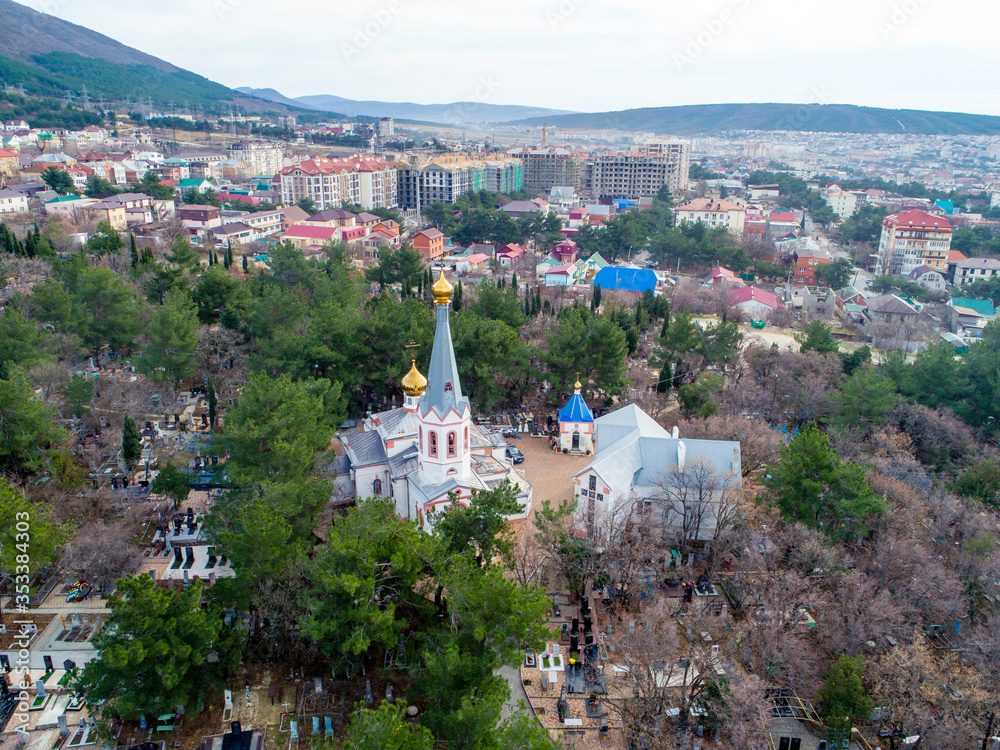 The Orthodox Church in the city of Gelendzhik is located in the old cemetery. The view from the height of bird flight.  In the background panorama of the city.