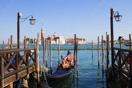 Gondolas moored on the pier of Saint Mark square (Piazza San Marco), in the background is San Giorgio di Maggiore church, Venice, Italy © julianjuly