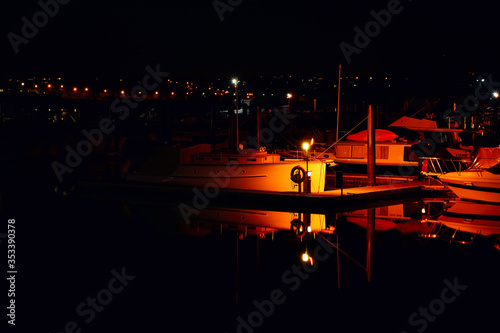 Spot-lighted sailing boats moored in Hobson Bay at night. Auckland, New Zealand
