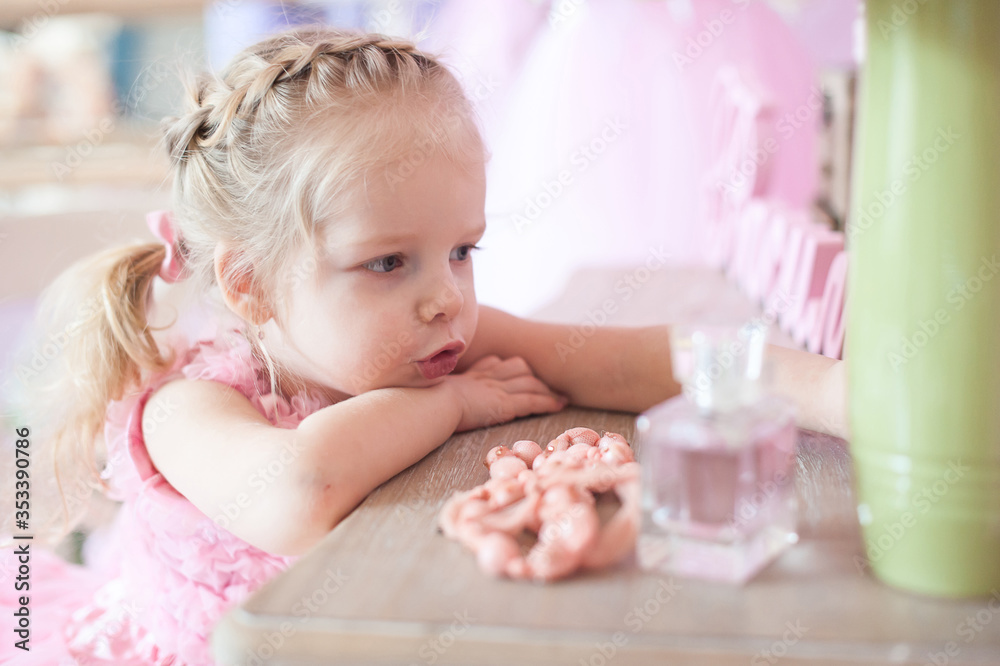 Little beautiful girl in a pink dress dreams, close-up Little beautiful girl in a pink dress dreams, close-up