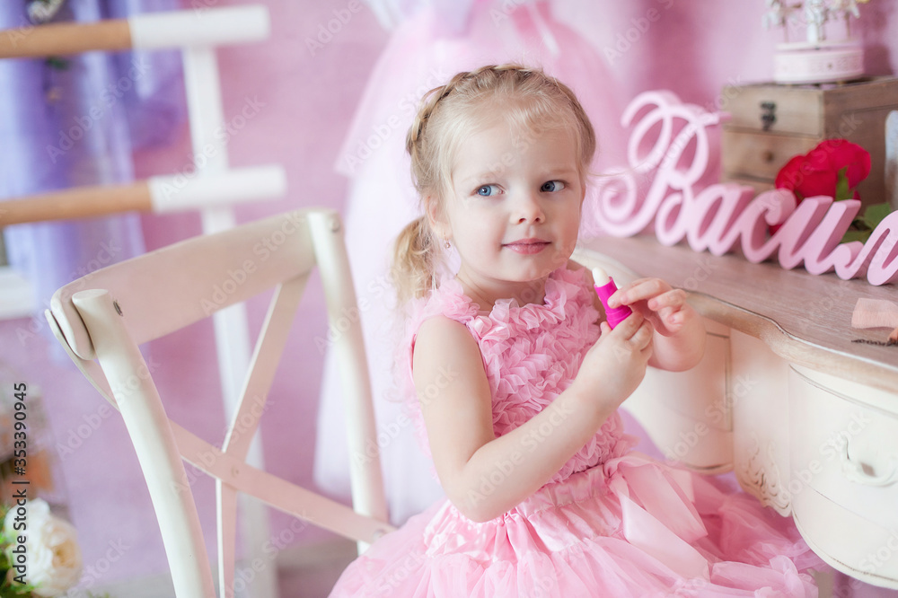 Little girl in a pink dress paints lips Little girl in a pink dress paints lips