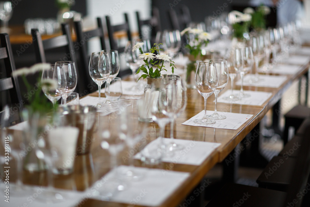 Tables setting at a luxury wedding. Table for guests. Dishes and drinks. Floral decorating, white chairs and table. Wedding table preparation. top view. Horizontal photo Tables setting at a luxury wedding. Table for guests. Dishes and drinks. Floral decorating, white chairs and table. Wedding table preparation. top view. Horizontal photo