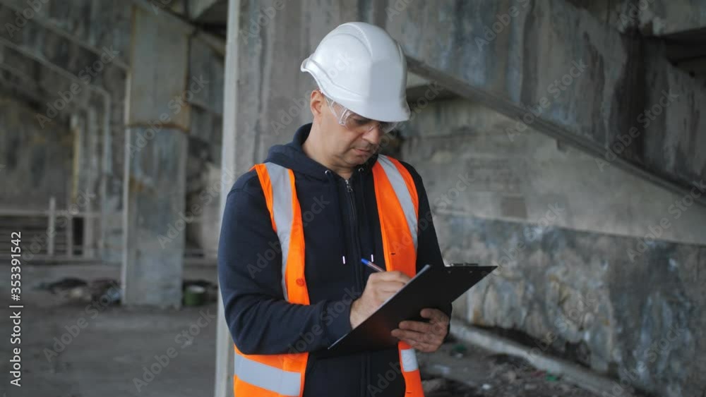 An engineering inspector inspects a building in a critical state of disrepair and records problems and damages in a report.