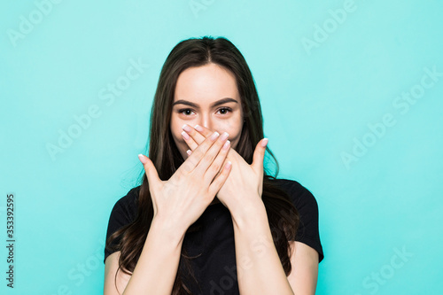 Young shocked girl cover mouth with hands isolated on turquoise background