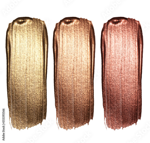 Creative brushstrokes of gold paint isolated on a black background. Gold paint texture.Acrylic gold paint. Smears of cosmetics, blush, highlighter, eye shadow, lipstick.