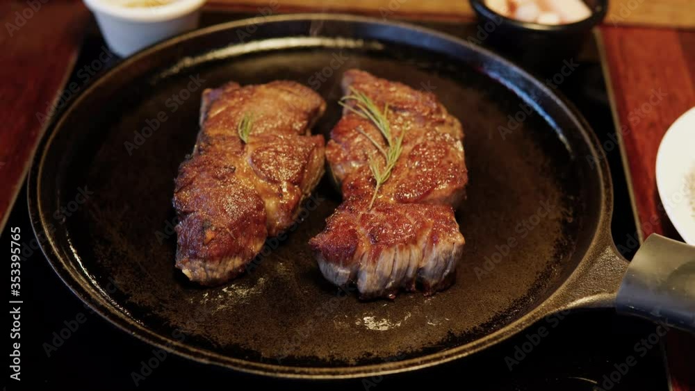 Fumes from Two pieces of steak on a frying pan in a Korean steak restaurant Fumes from Two pieces of steak on a frying pan in a Korean steak restaurant