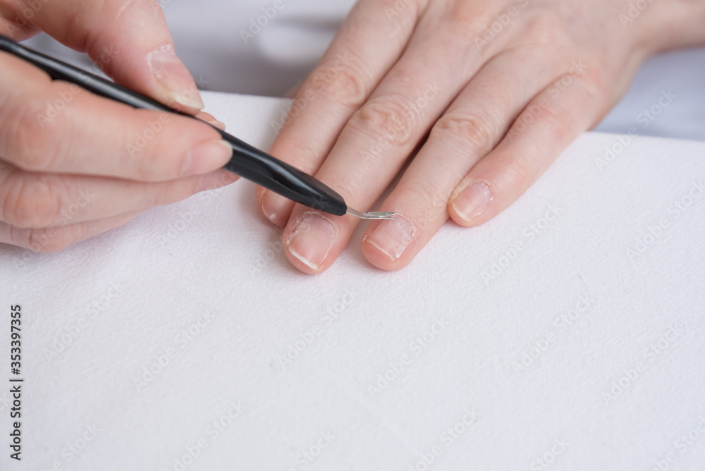 Home manicure. Self-treatment of nails during the pandemic and quarantine. Cuticle removal with a special tool. Close up. Home manicure. Self-treatment of nails during the pandemic and quarantine. Cuticle removal with a special tool. Close up.