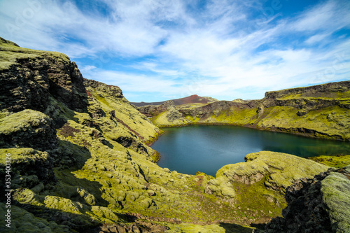 Volcanic lake inside of a crater in Iceland. Volcanic crater lake in southern Iceland. Highland of Iceland. Beautiful crater lake with a turquoise water color covered with green moss