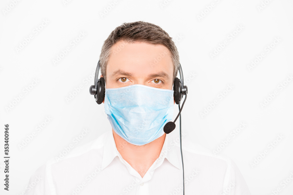 Portrait of mature man worker of call center assistance with medical mask wear on face and headset with microphone help other people isolated on gray background, stop pandemic of corona virus concept Portrait of mature man worker of call center assistance with medical mask wear on face and headset with microphone help other people isolated on gray background, stop pandemic of corona virus concept