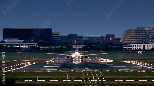 Airplane during take off from Hamburg airport (HAM). Late evening with runway ilumination. Visible heat haze, cause of high temperature on the runway