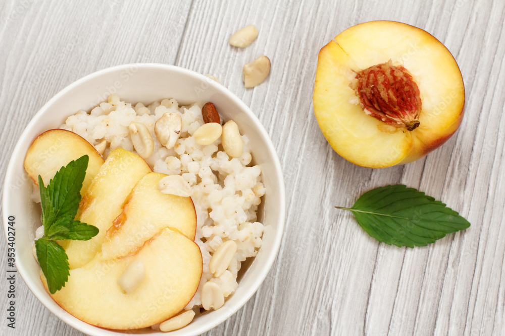 Sorghum salad with nuts and fresh peach on gray boards. Sorghum salad with nuts and fresh peach on gray boards.
