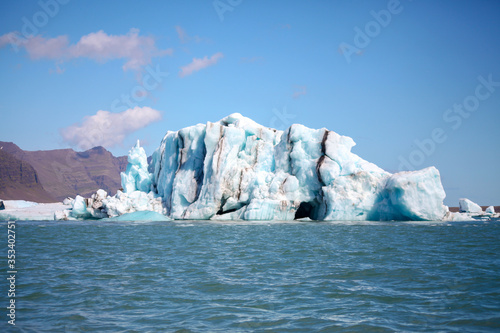 Icebergs floating. Ices and volcanic ash. Glacier lagoon. Melting ice. South coast Iceland.Volcanic ash on the arctic ice. Ice age glacier crevasse melting fast. Global warming. The edge of a glacier