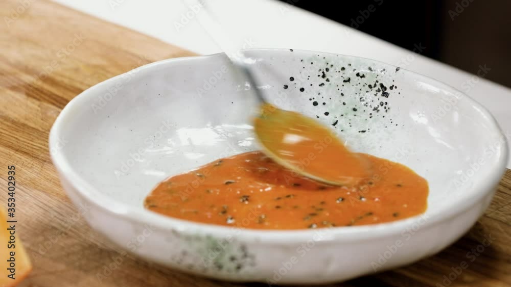 Close up of man putting a sea buckthorn sauce onto the plate with spoon. 4K Close up of man putting a sea buckthorn sauce onto the plate with spoon. 4K