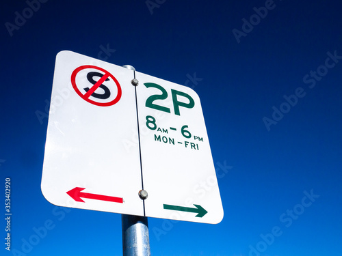 Australian parking sign against the blue sky. 2P indicates only 2 hour parking time allowed between 8am to 6pm Monday to Friday. No restriction on the other times. Victoria, Australia. photo