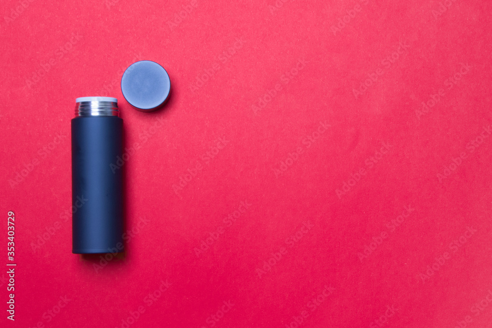 black thermos cup with open cover on red background with copy space black thermos cup with open cover on red background with copy space