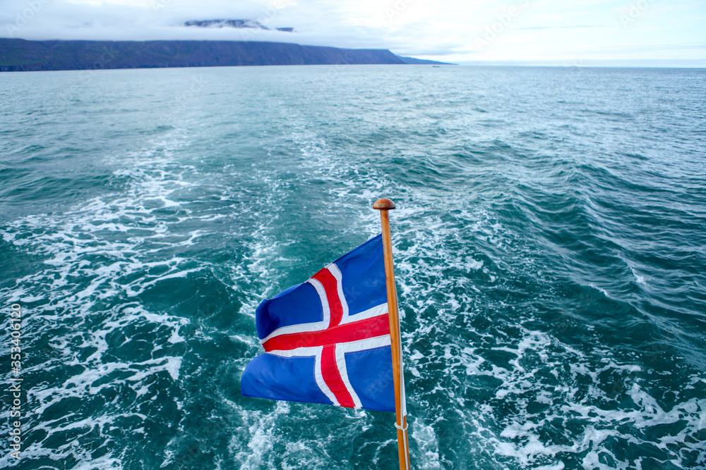 Icelandic Flag waving in the wind  on a boat. The national flag of Iceland waving on a whale watching boat. Sailing a boat on the ocean in the Arctic. 