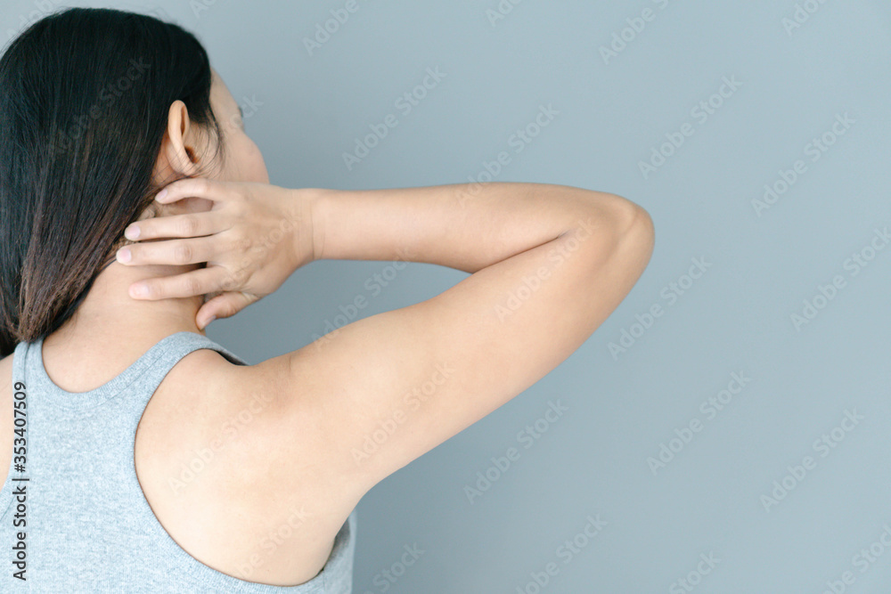 Closeup woman holding neck with pain after waking up on bed, healthy care and medical concept Closeup woman holding neck with pain after waking up on bed, healthy care and medical concept