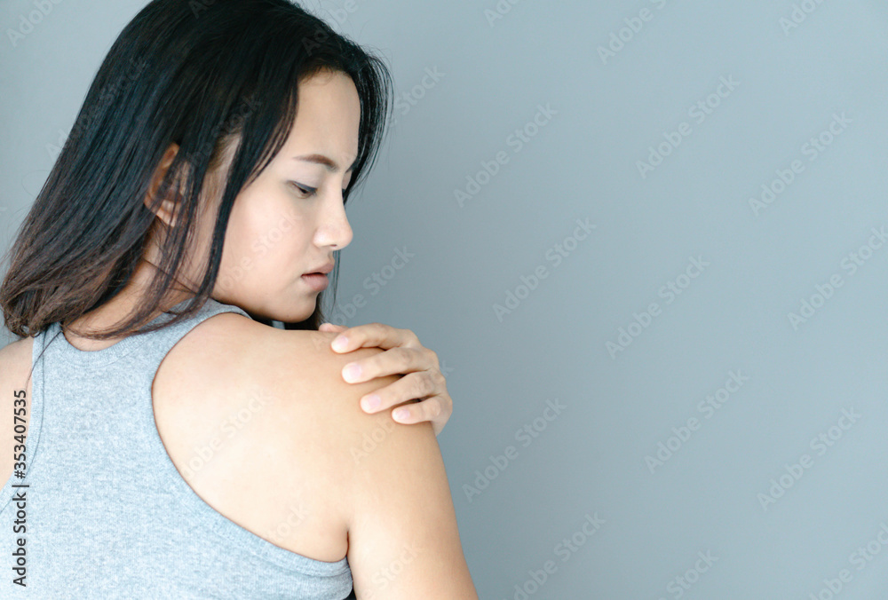 Closeup woman hand holding shoulder with pain on white background Closeup woman hand holding shoulder with pain on white background