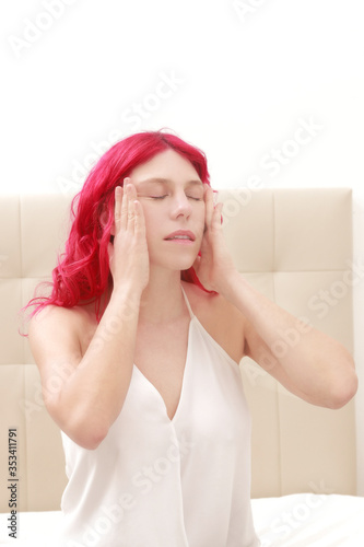 Mujer en habitación haciendo yoga facial estirándose la piel photo