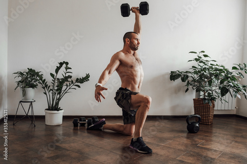 Family of mom, dad and baby joyfully doing fitness and crossfit at home