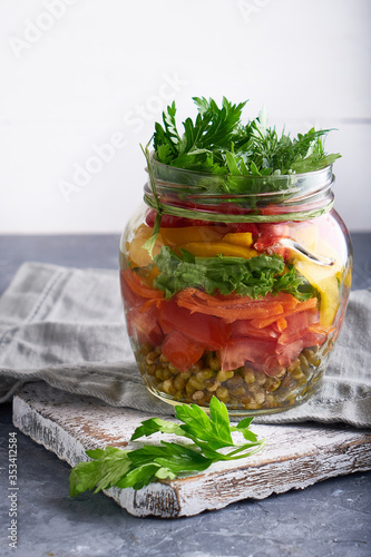 Tasty mason salad in jar. Homemade and healthy food Served on gray table