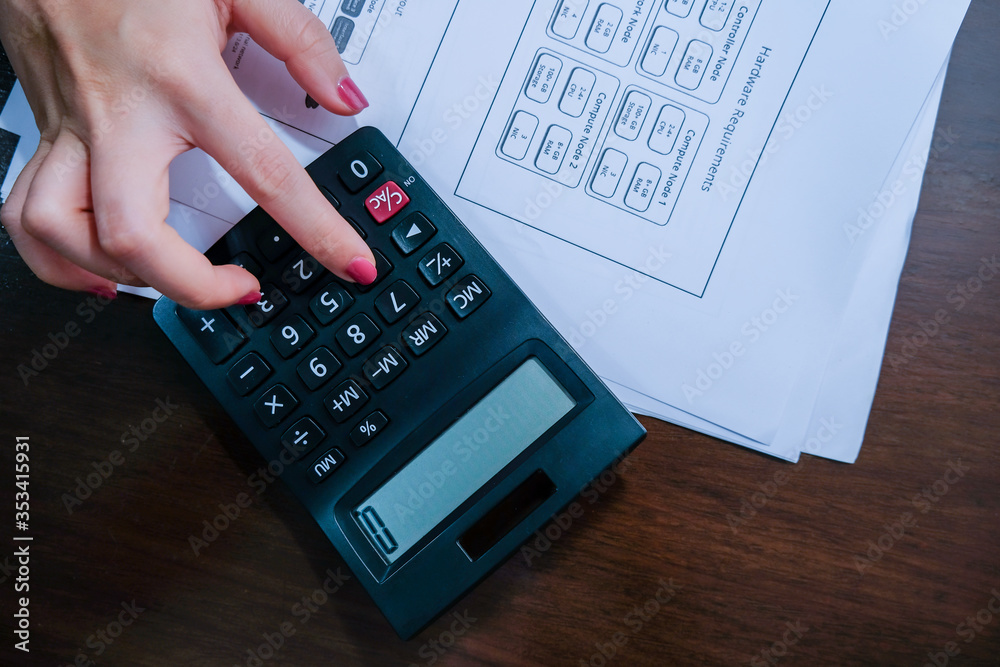 High view of Financial data analyzing hand writing and counting on calculator at home on wooden desk,Business and finance concept.. High view of Financial data analyzing hand writing and counting on calculator at home on wooden desk,Business and finance concept..