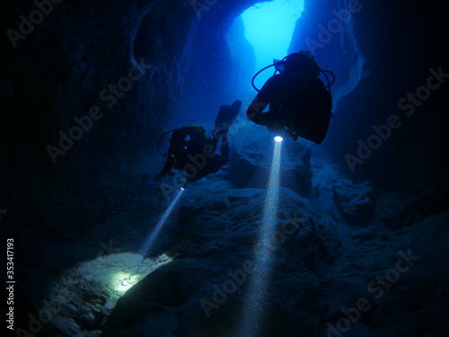 cave diving underwater scuba divers exploring caves ocean scenery photo