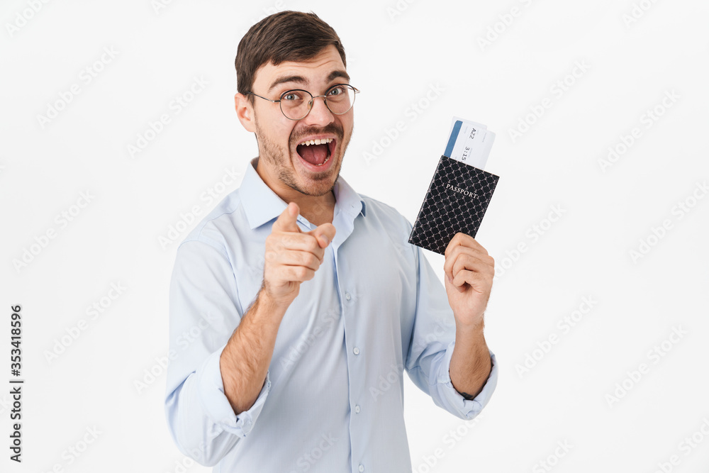 Photo of delighted man holding passport and pointing finger at camera Photo of delighted man holding passport and pointing finger at camera
