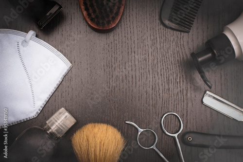 Barber tools on wood dark background,scissor,razor,brush,barber machine,black comb,soap dispenser, protective face mask and sanitizer alcohol gel.