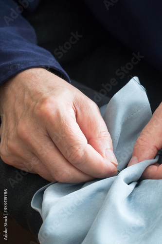 Man sewing a new button on a fashionale shirt