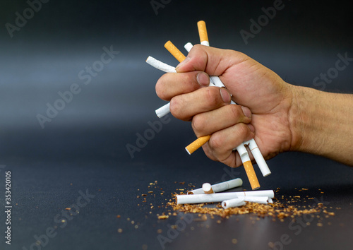 close up man's hand is crumpling a cigarette in his hand, the concept of quitting smoking to maintain health and prevent lung cancer, World No Tobacco Day.