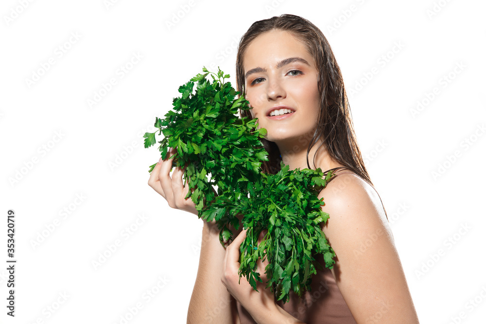 Green splash. Close up of beautiful young woman with parsley on white background. Concept of cosmetics, makeup, natural and eco treatment, skin care. Shiny and healthy skin, fashion, healthcare. Green splash. Close up of beautiful young woman with parsley on white background. Concept of cosmetics, makeup, natural and eco treatment, skin care. Shiny and healthy skin, fashion, healthcare.