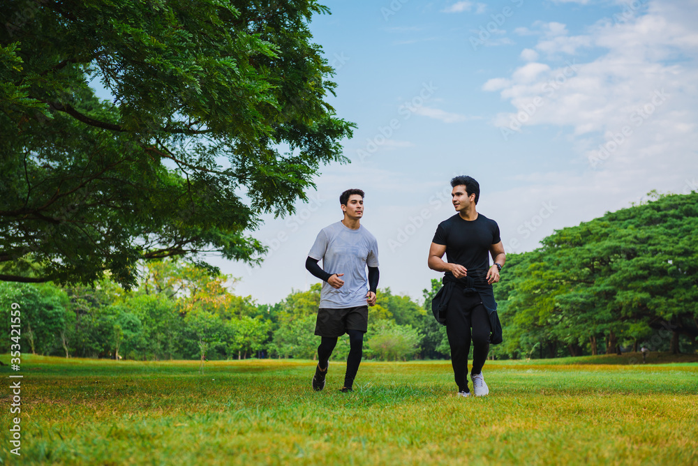 Sportman running with his friend in the green park Sportman running with his friend in the green park