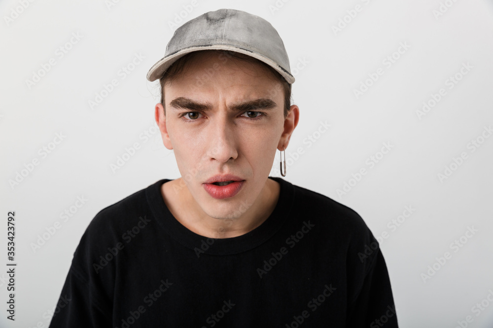 Portrait closeup of perplexed young man wearing black clothes looking at camera Portrait closeup of perplexed young man wearing black clothes looking at camera