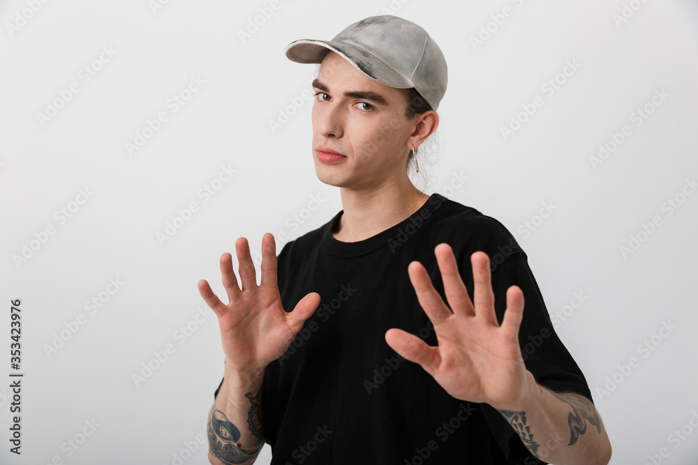 Portrait of young caucasian man wearing black clothes looking at camera and gesturing stop sign with hands Portrait of young caucasian man wearing black clothes looking at camera and gesturing stop sign with hands