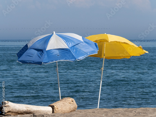 colorful blue and yellow beach umbrellas on a sunny day at the seashore 